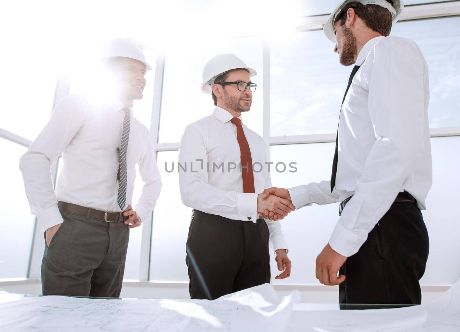 businessman and architect shaking hands by asdf