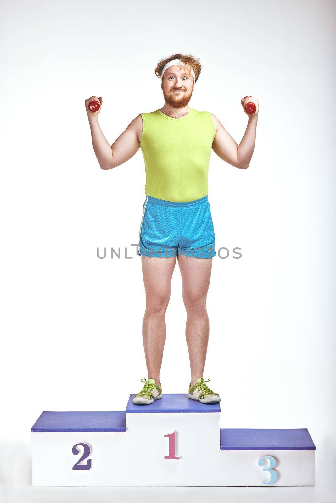 Red haired, bearded, plump man is standing on a pedestal by friendsstock