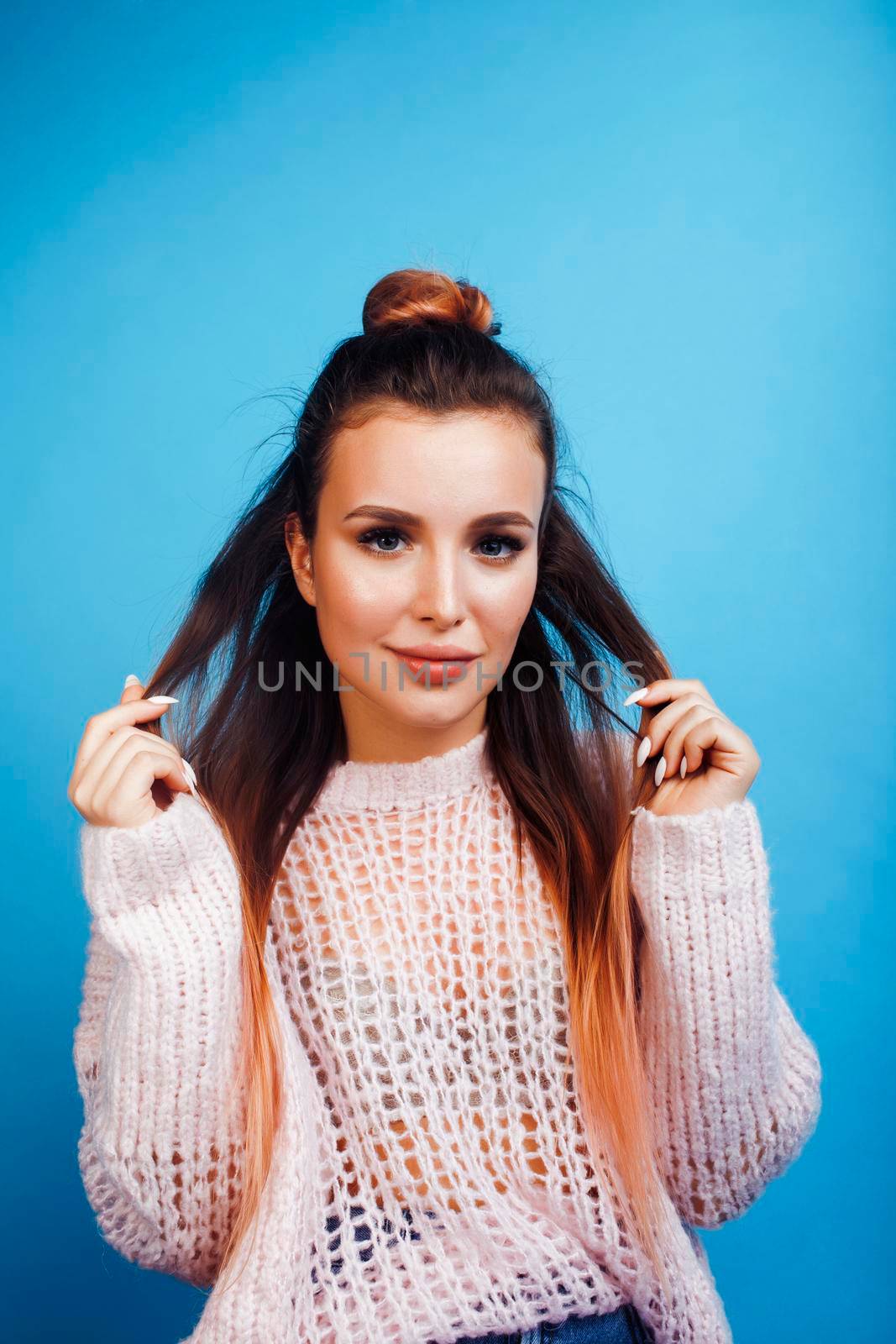 young pretty modern hipster girl posing emotional happy on blue background, lifestyle people concept close up