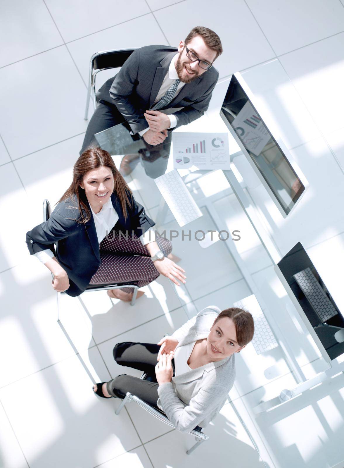 top view.business colleagues sitting at the Desk and looking at the camera.photo with copy space