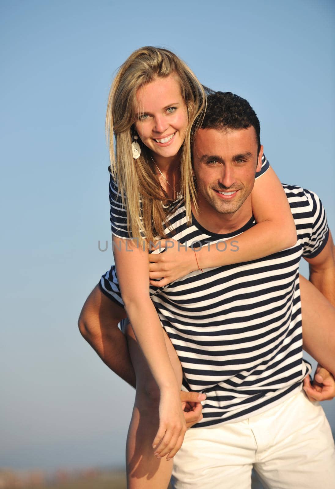 happy young couple have romantic time on beach at sunset