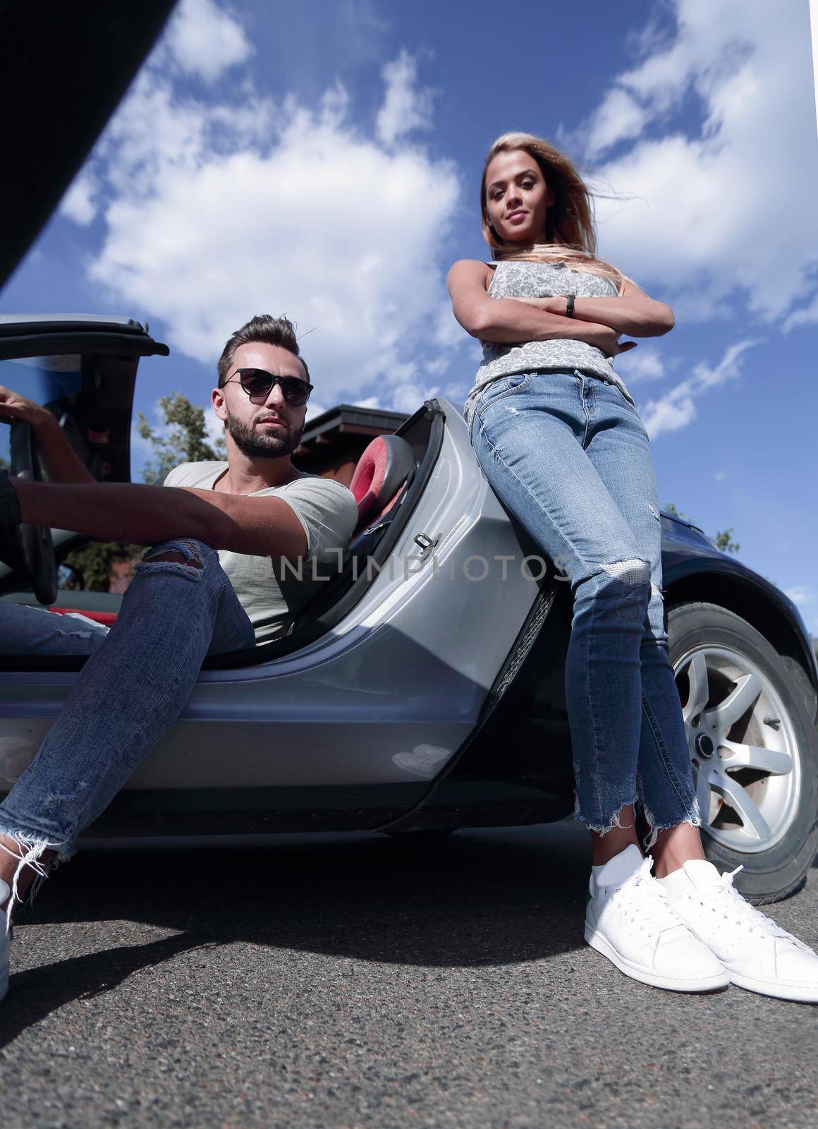 bottom view.young couple standing near the car by asdf