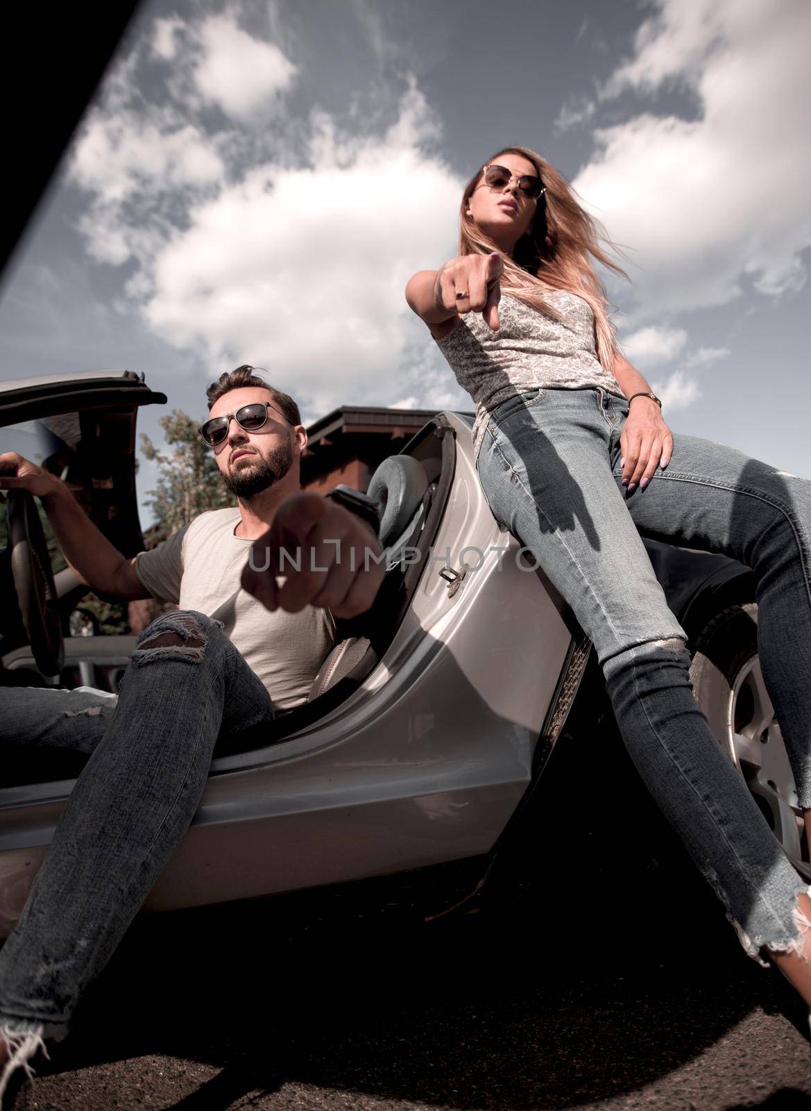 bottom view.modern young couple standing near the car. the concept of lifestyle