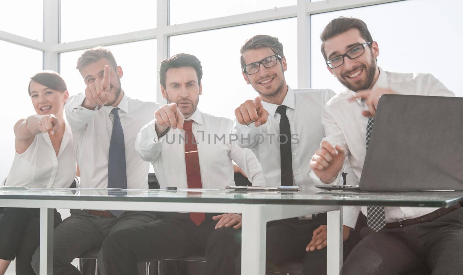 group of employees sitting at the Desk and pointing at you by asdf