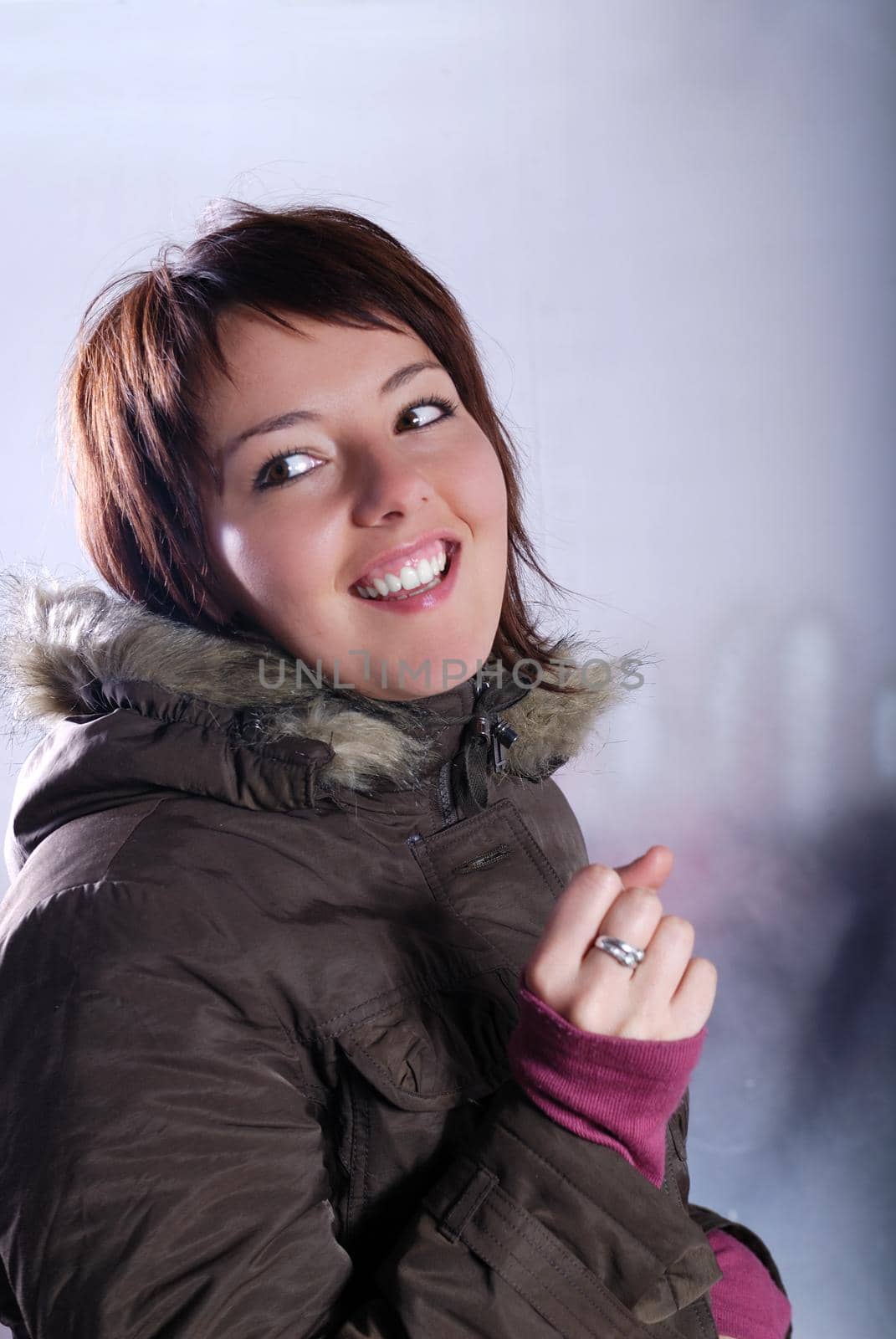 Cute young woman smiling in winter jacket by dotshock