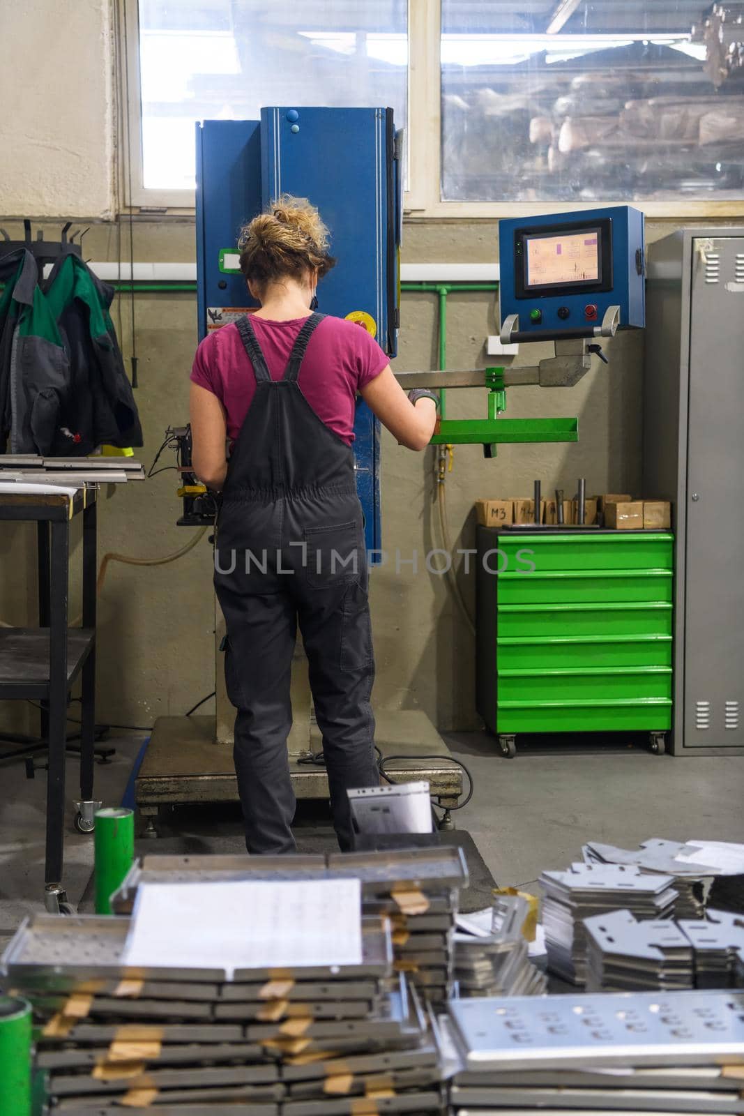 woman wearing a mask due to coronavirus pandemic while working in the modern metal industry and using a drill. High quality photo