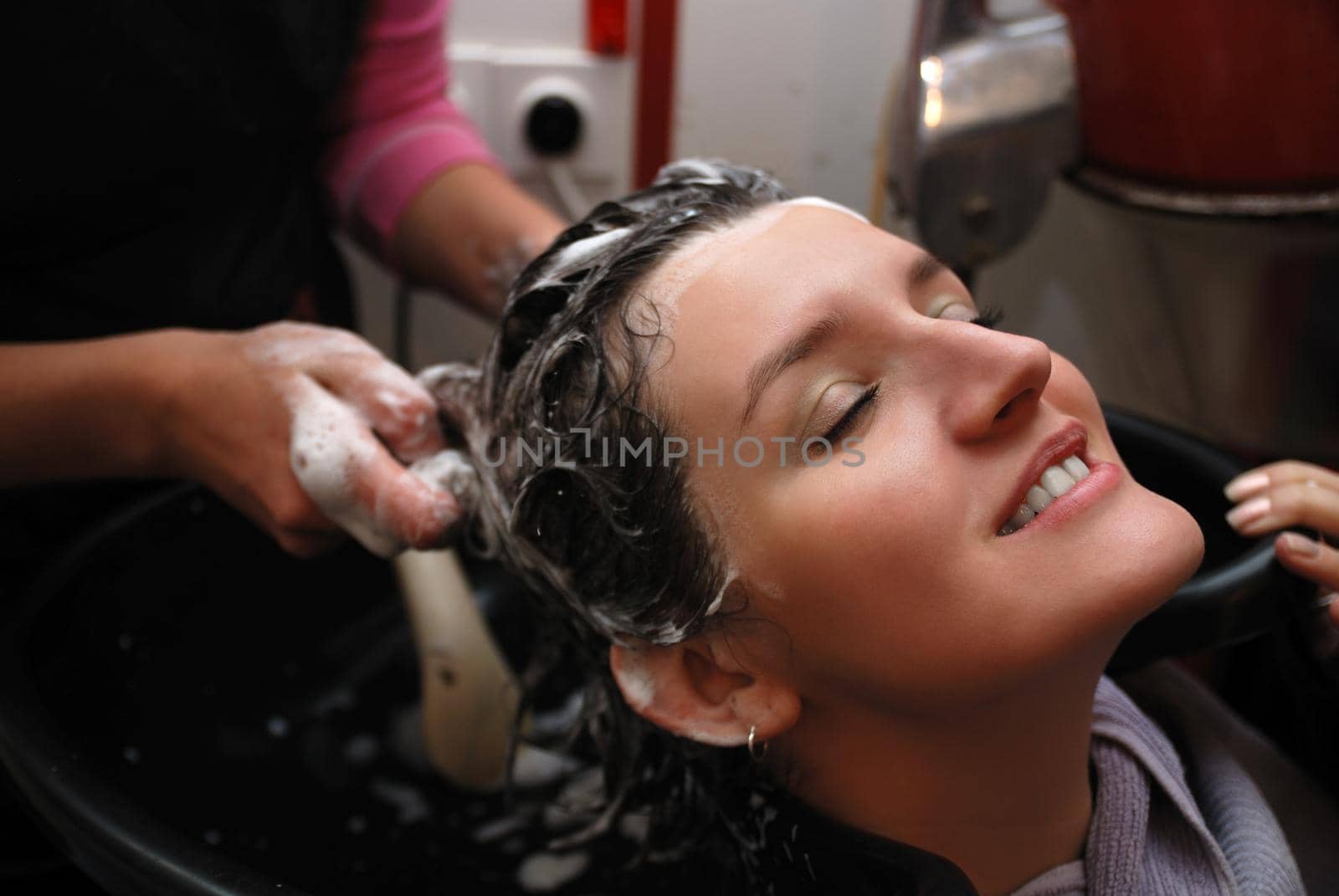 Beautyful young woman enjoying a hair-wash by dotshock