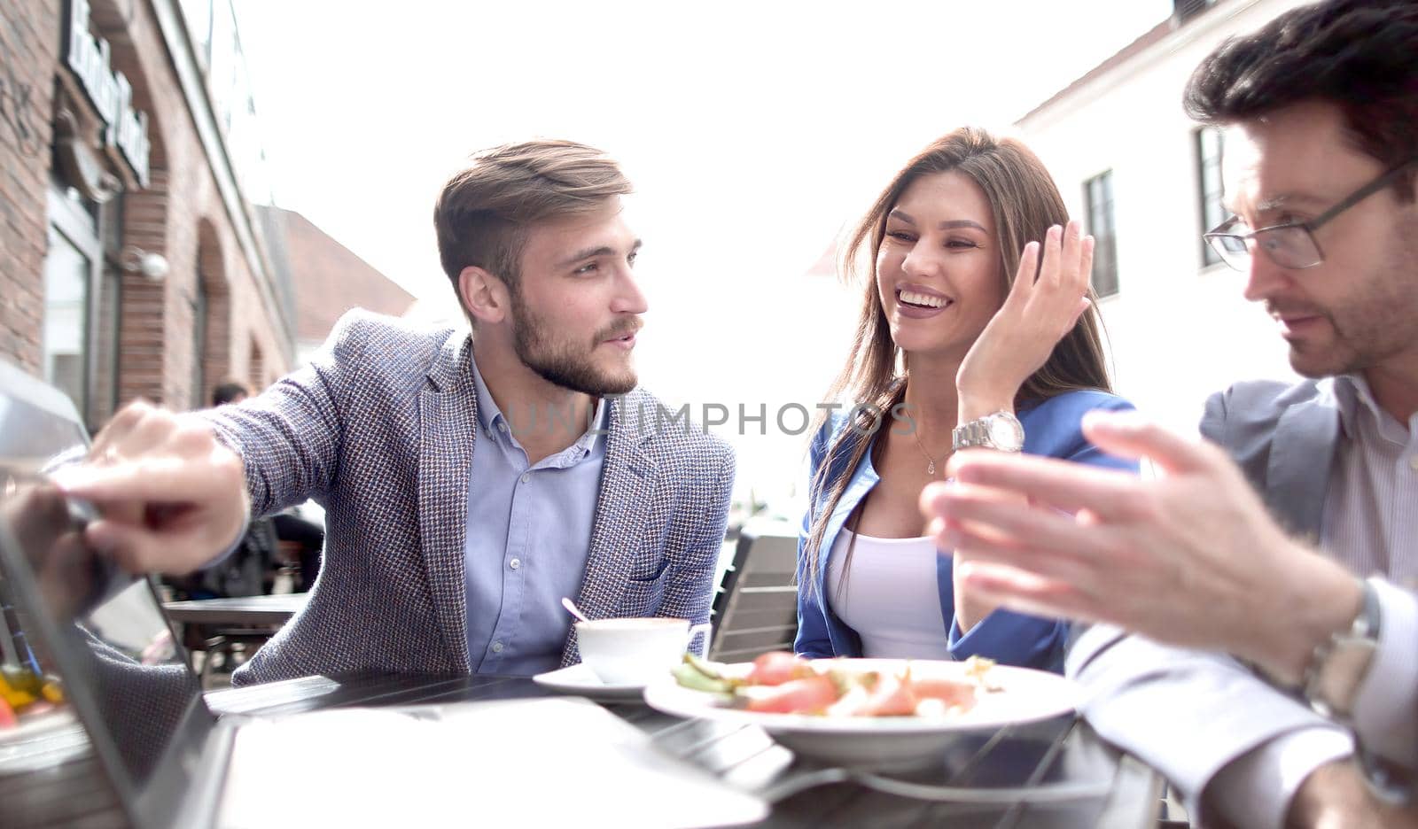 colleagues discuss new information at a table in a cafe by asdf