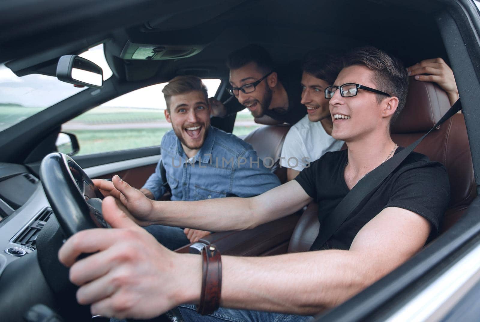 side view . friends sitting in the car and looking at the camera.joint trip