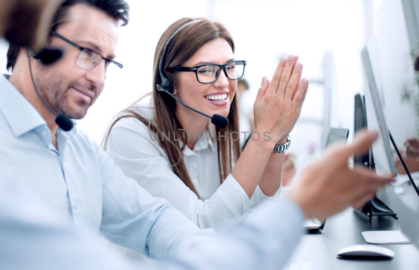 close up.happy call center employees sitting at their Desk