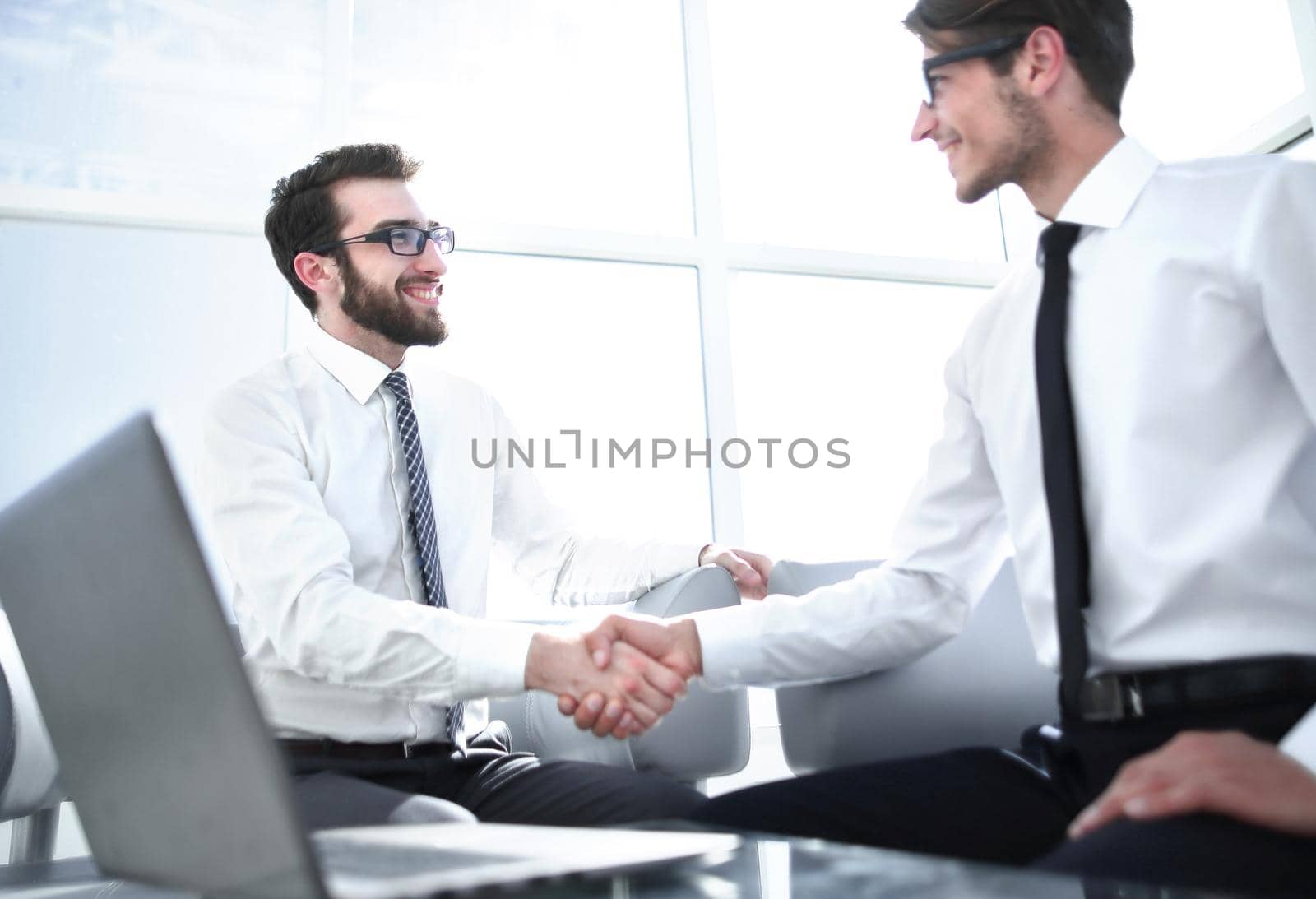 business partners shake each other sitting in the office by asdf