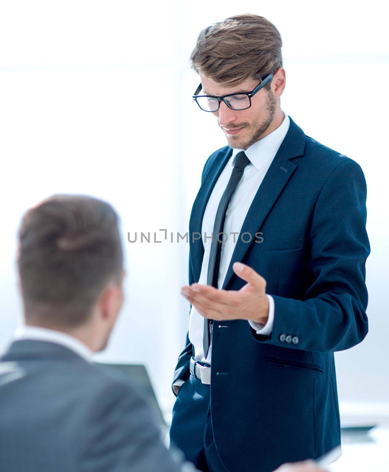 two businessmen at the office greeting each other by the hand and smiling