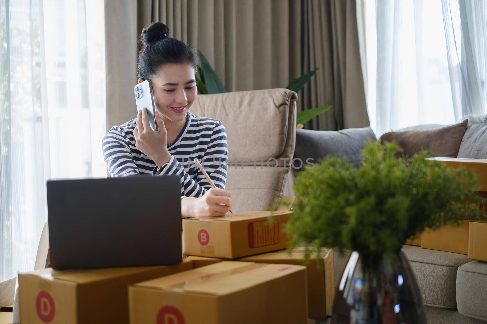 Asian small business owner checking order by smartphone at home office. Business retail market and online sell marketing delivery, SME e-commerce concept