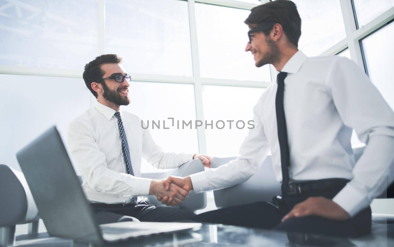 business partners shake each other sitting in the office. the concept of cooperation