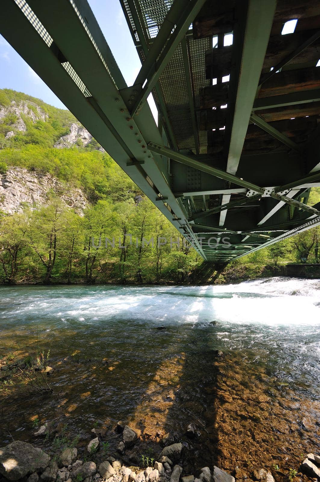 beautiful bridge in nature over wild river