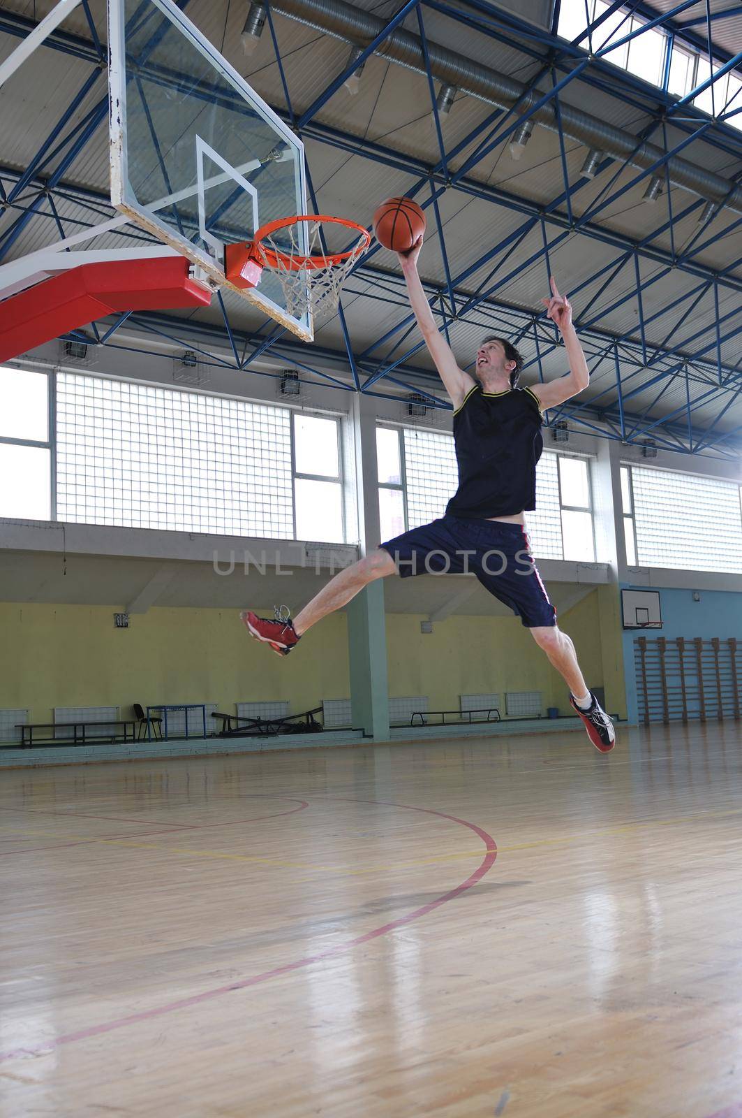 one healthy young  man play basketball game in school gym indoor