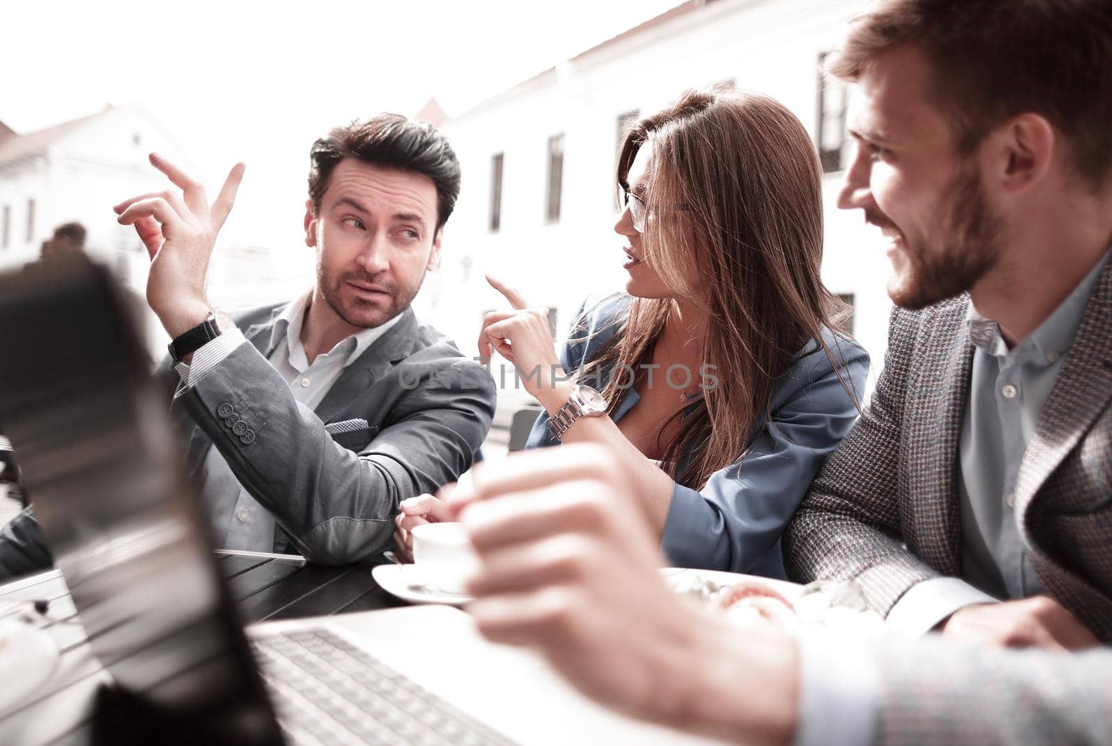 close up.business team sitting at a table in a street cafe.the concept of teamwork