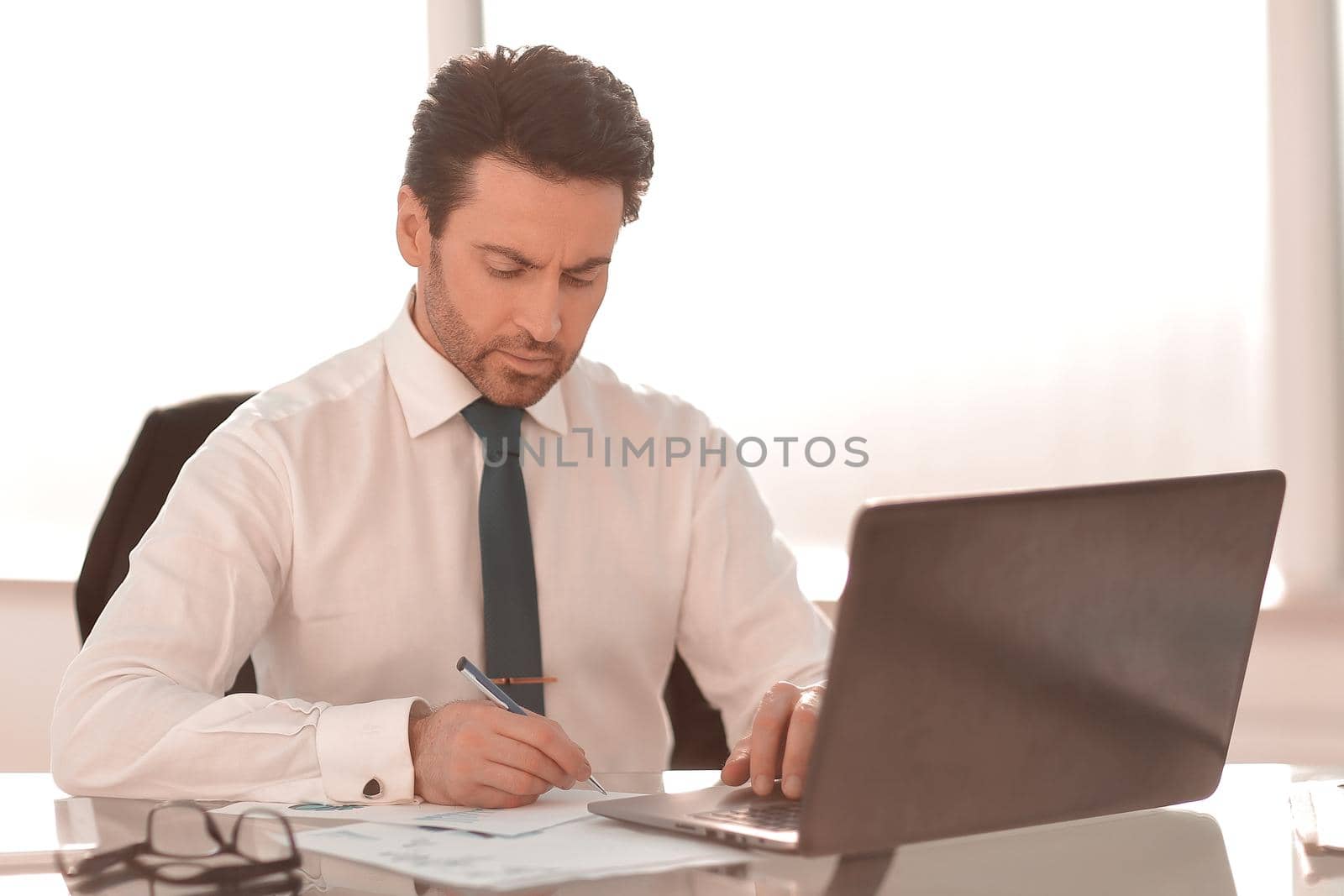 close up. serious businessman checking financial report.business concept