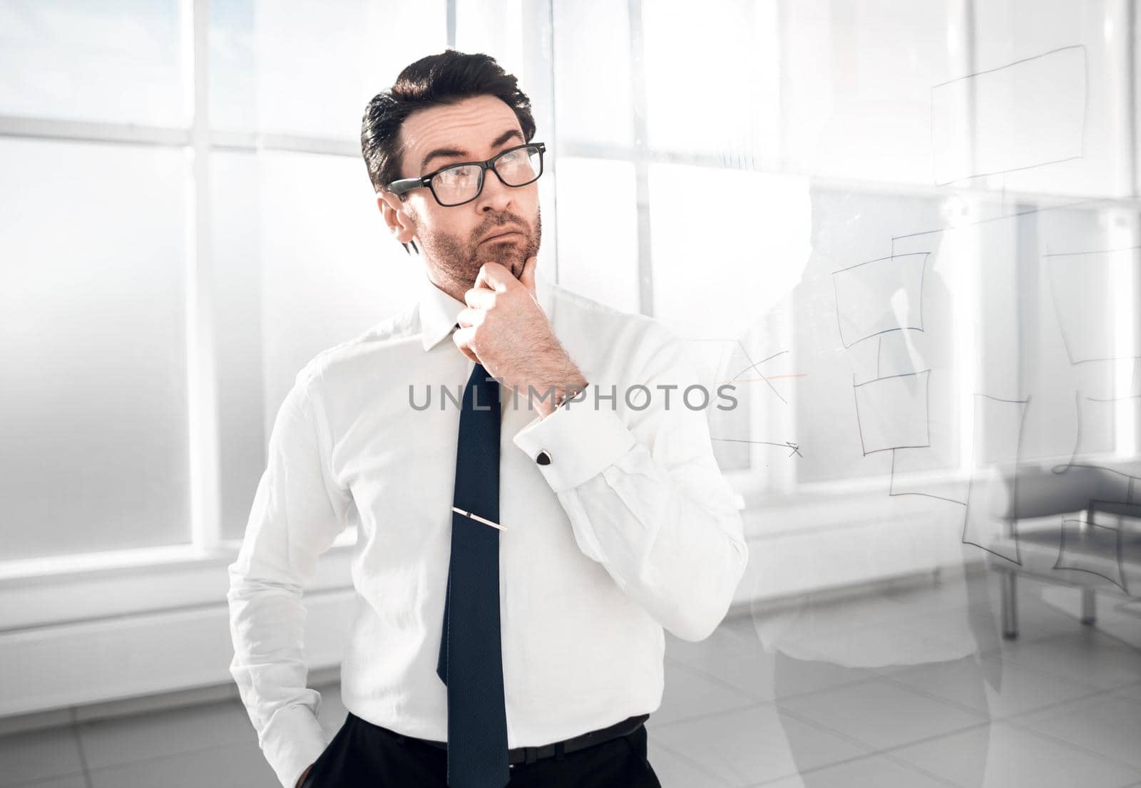 pensive businessman standing near a transparent Board.photo with copy space