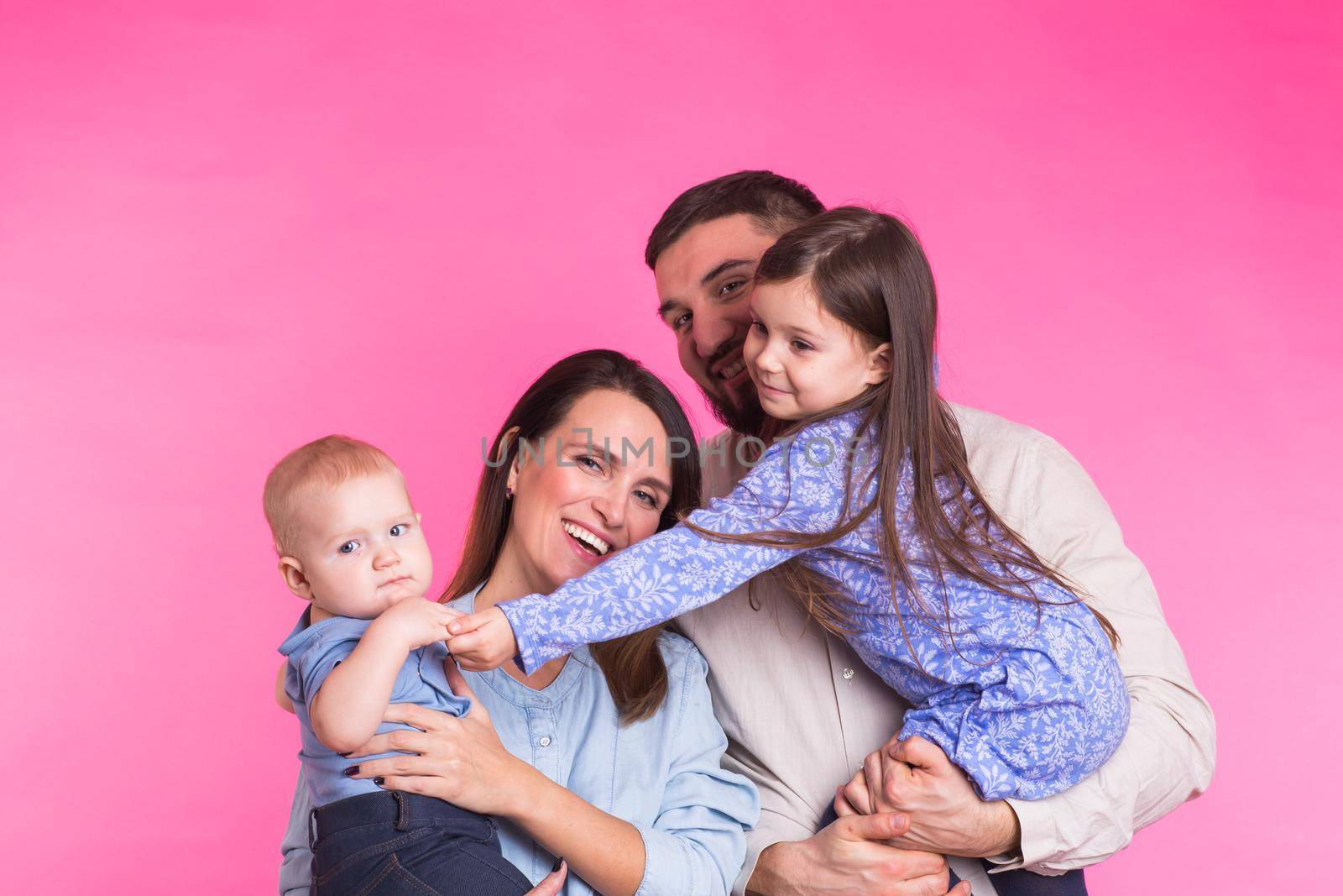 Portrait of Young Happy Mixed Race Family over pink background