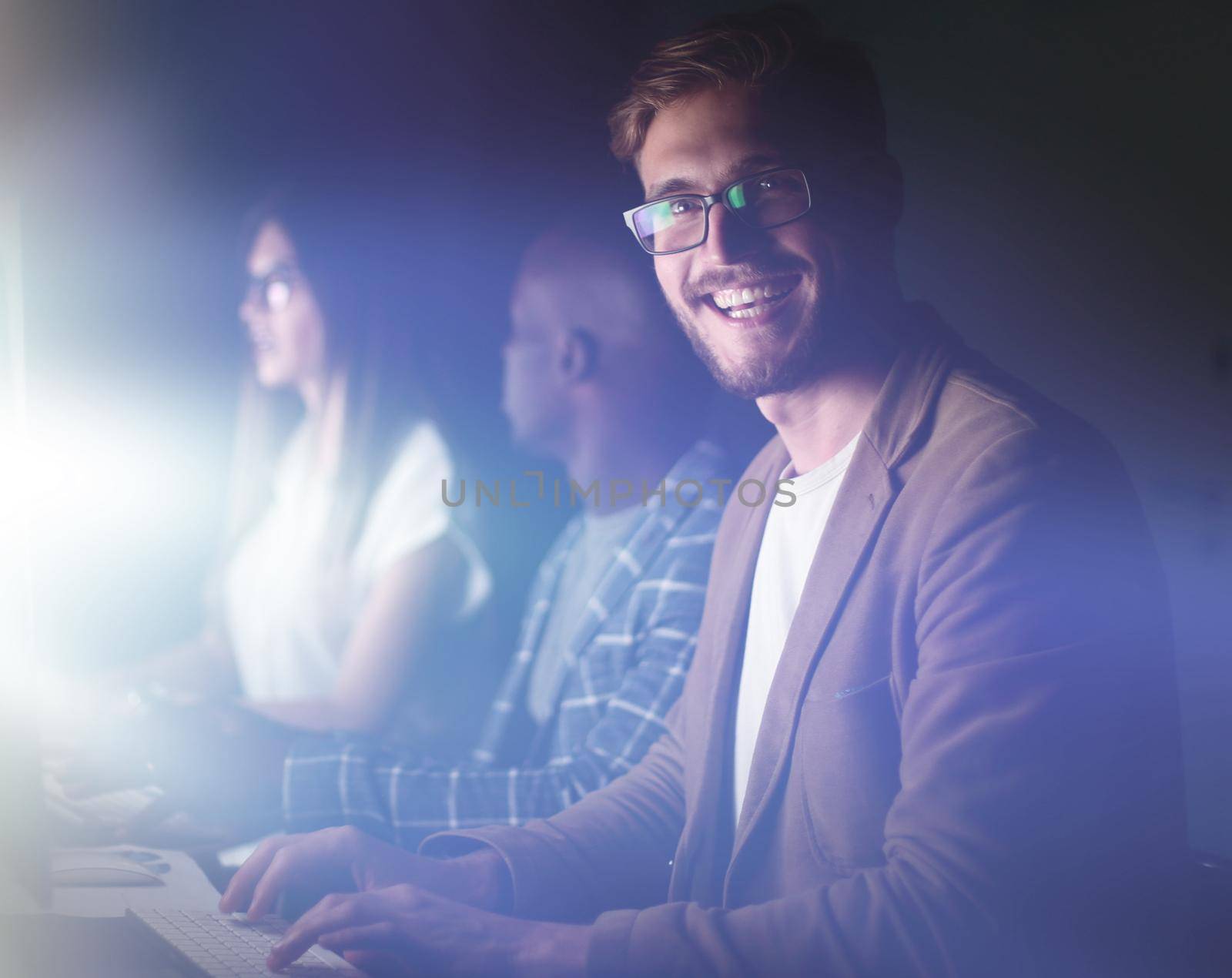 businessman working on the computer in the office at night. by asdf