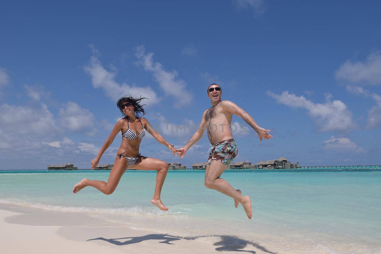 happy young couple have fun on beach by dotshock