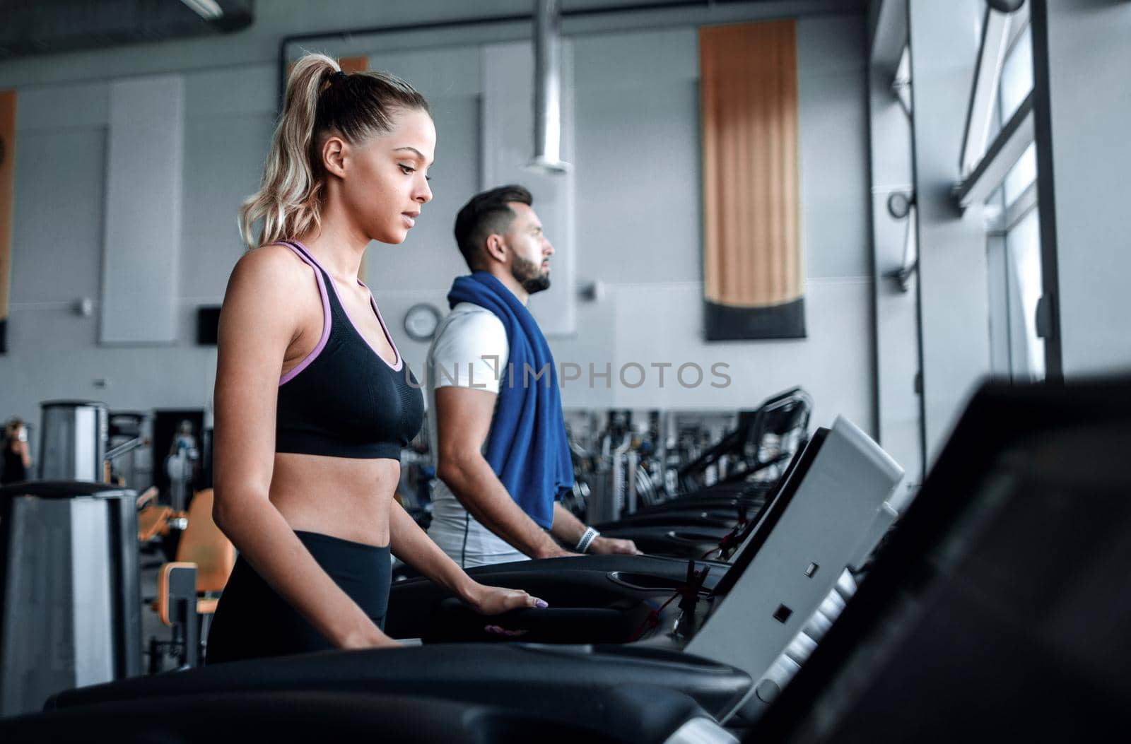 beautiful sports people work on the treadmill in the gym . healthy lifestyle