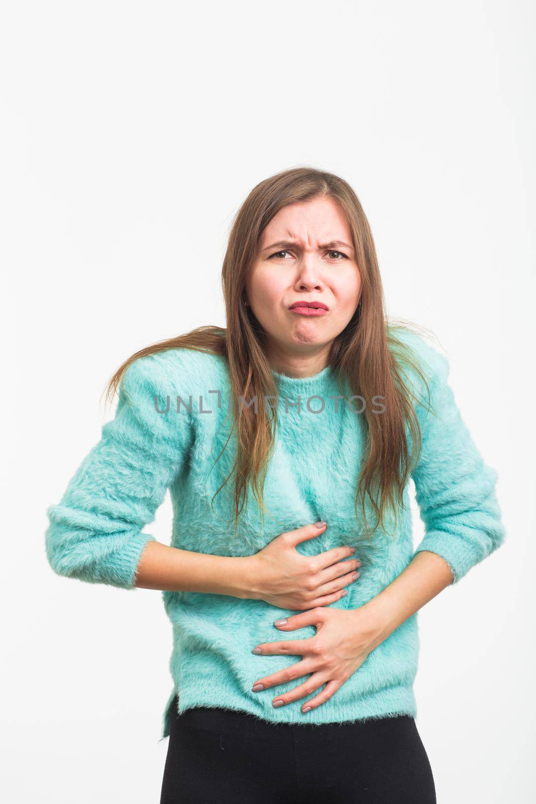 Woman with stomach pain on blue background.