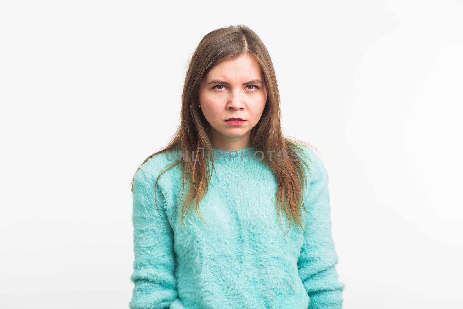 Portrait of angry woman standing on white background.