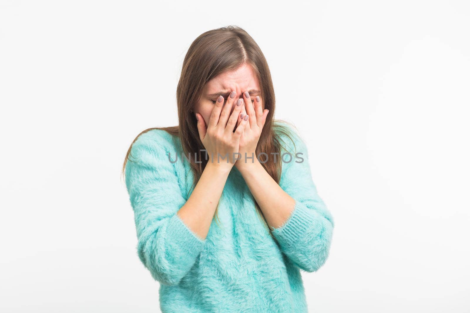 A sad beautiful woman crying on white background