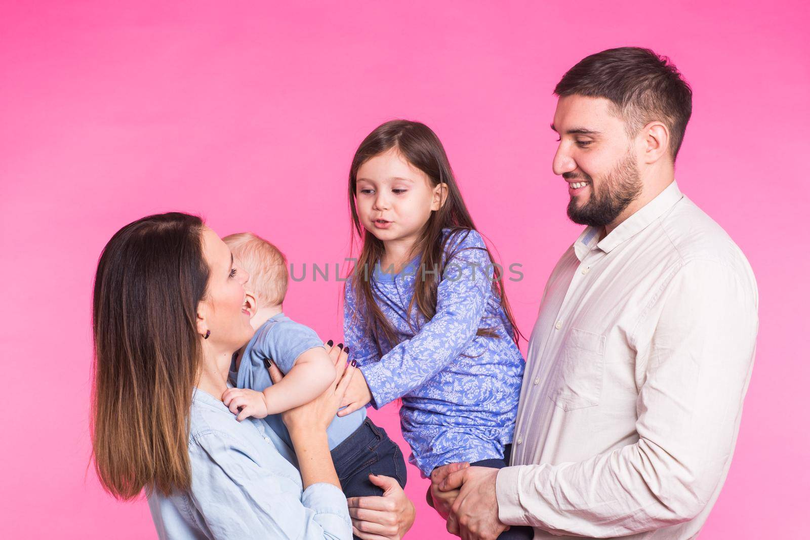 Happy mixed race family portrait smiling on pink background by Satura86