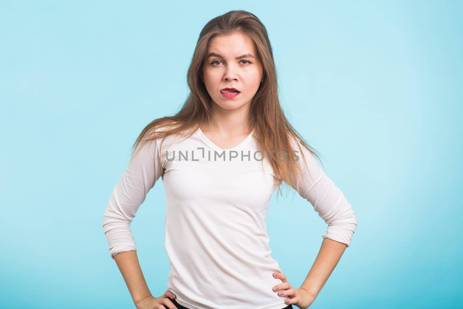 Funny beautiful young woman have fun over blue background