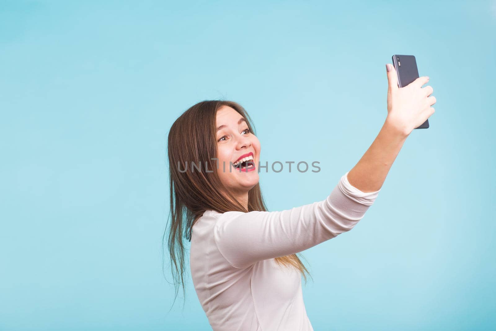 Young woman talking with friend through a video call on a smartphone. Beautiful girl having a video chat with man on mobile phone