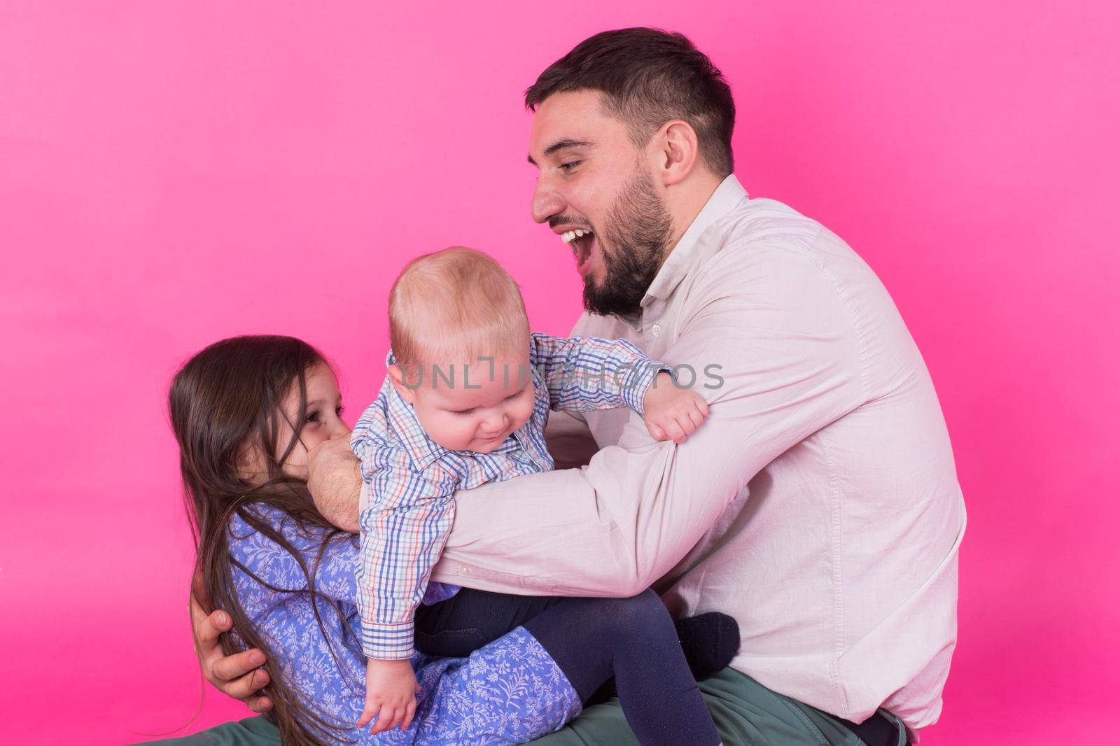 Father with children having fun on pink background by Satura86