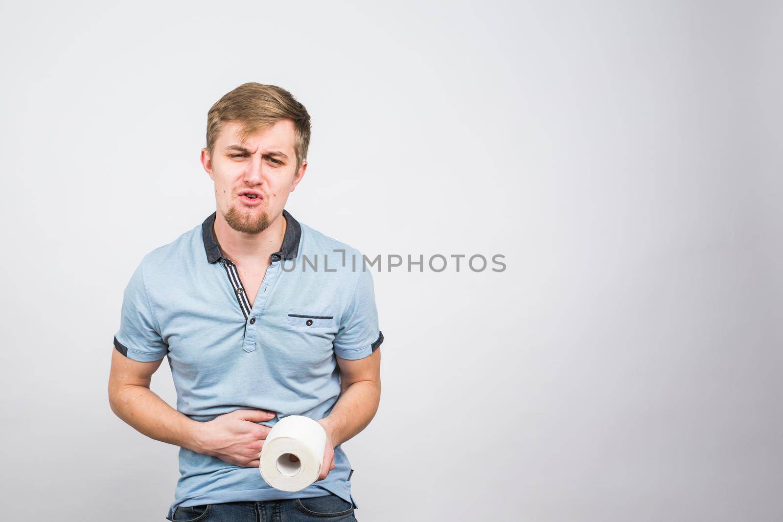 Young Man with Toilet Paper on the White Background - health problem concept.