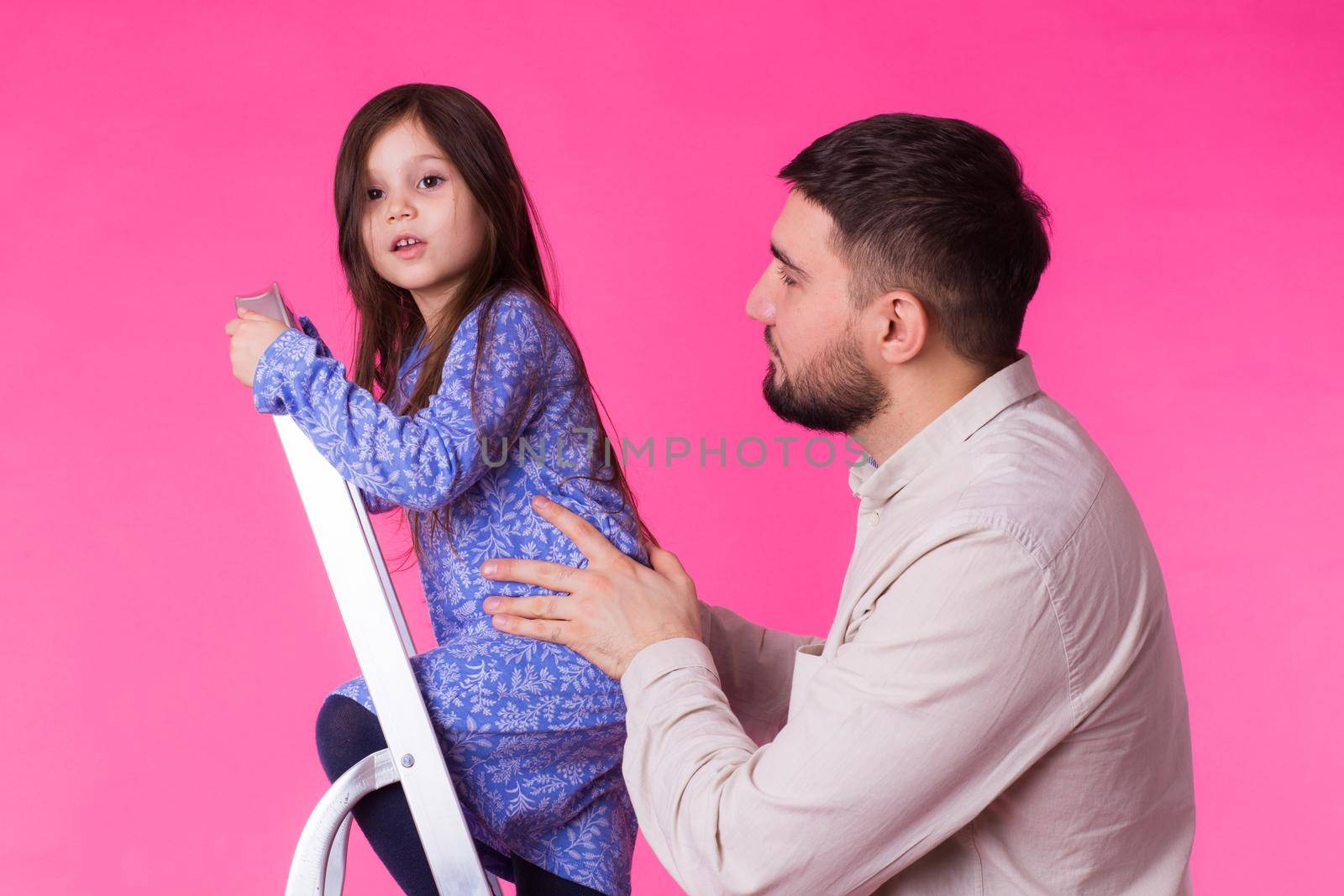 Father and her little daughter over pink background. Adult man and baby girl are happy by Satura86