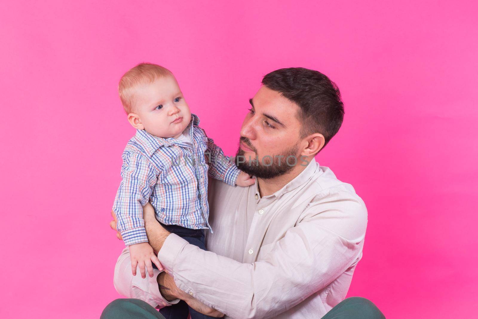 Baby in the daddy hands. Pink background. by Satura86