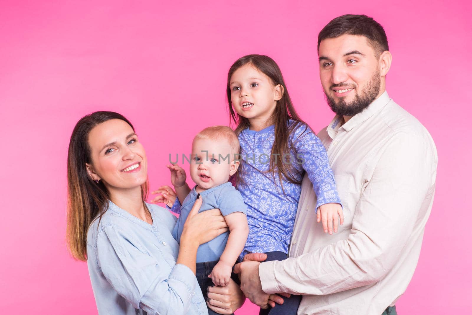 Happy mixed race family portrait smiling on pink background by Satura86