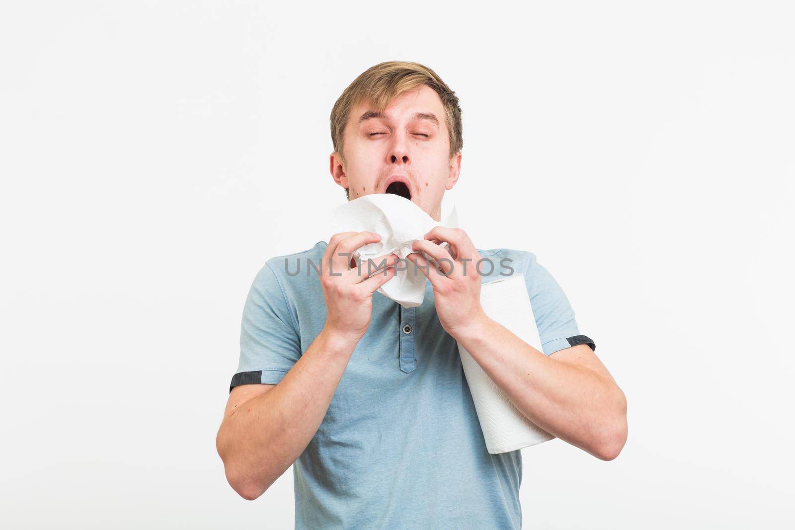 Man Sneezing Studio Portrait Concept. Young man with handkerchief. Sick guy isolated has runny nose