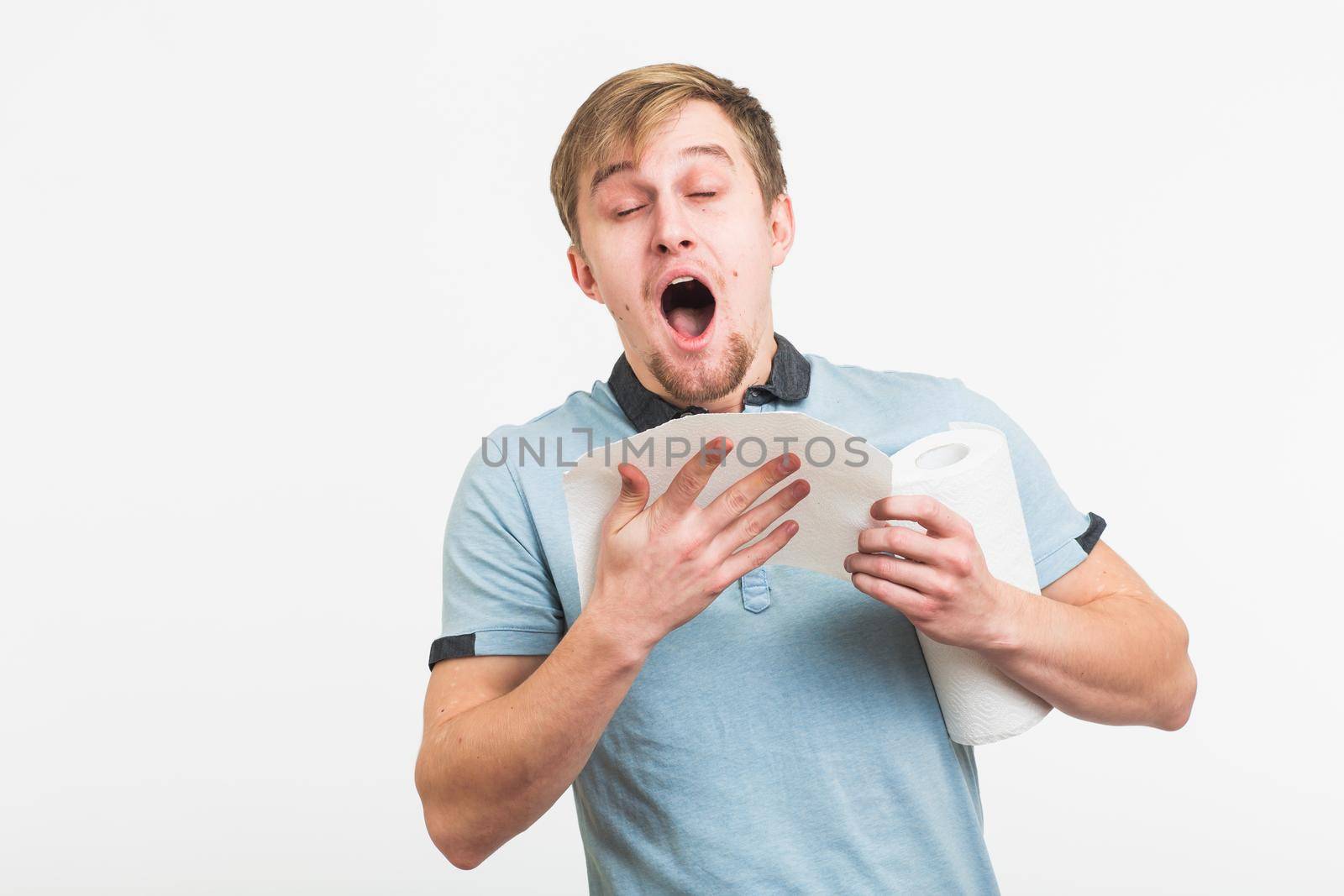 Man Sneezing Studio Portrait Concept. Young man with handkerchief. Sick guy isolated has runny nose