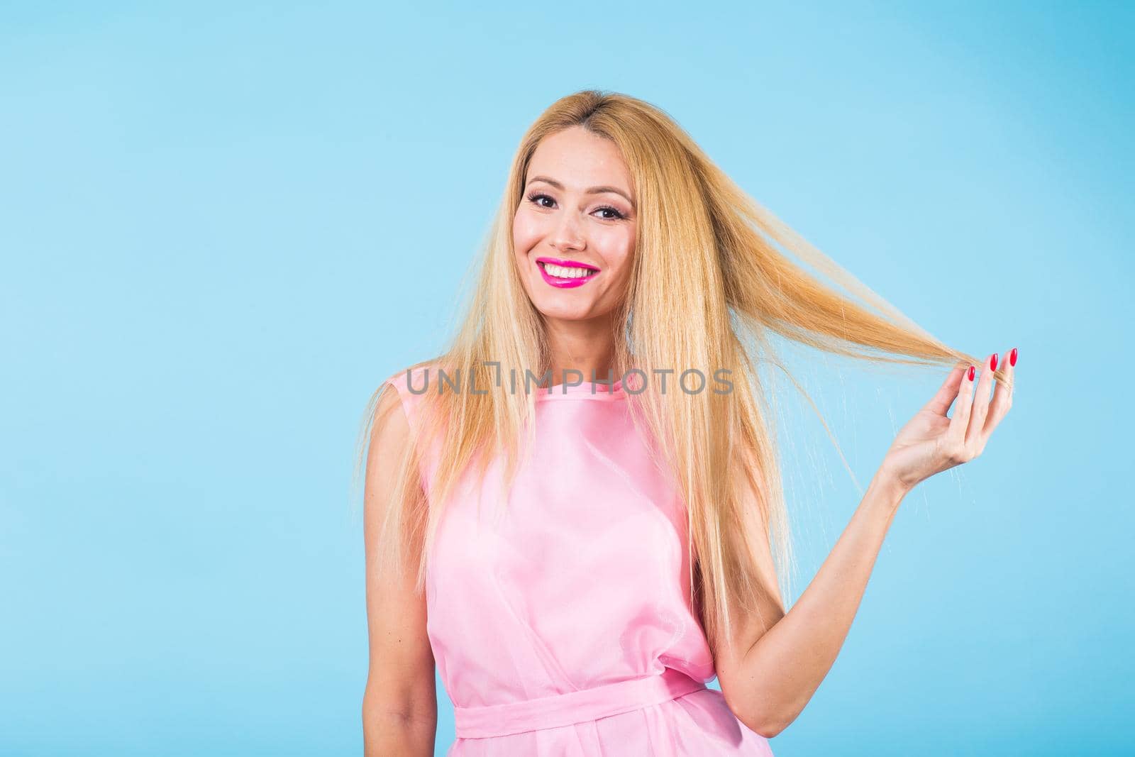 Portrait of happy cheerful smiling young beautiful blond woman on blue background by Satura86