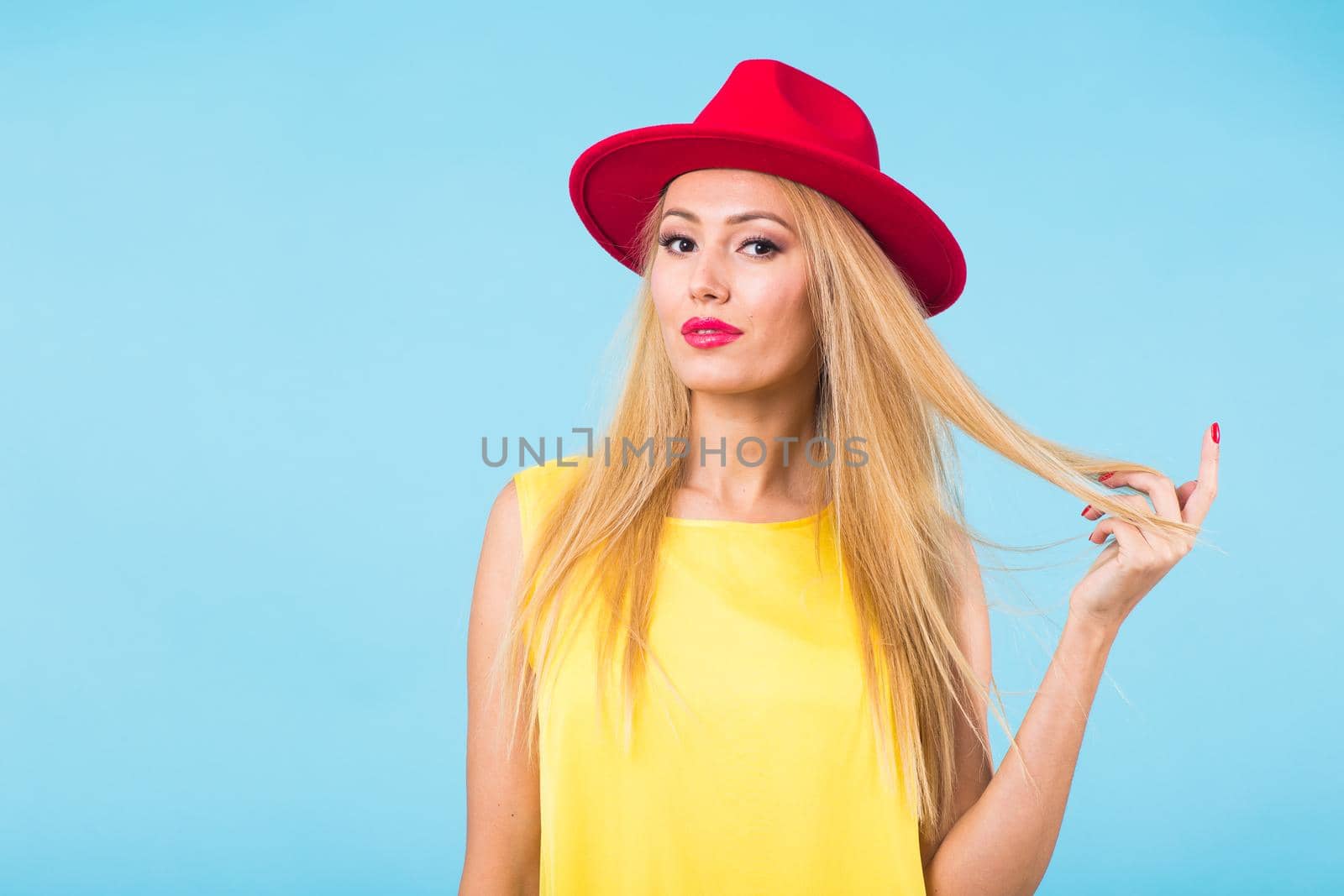 Portrait of happy cheerful smiling young beautiful blond woman on blue background.