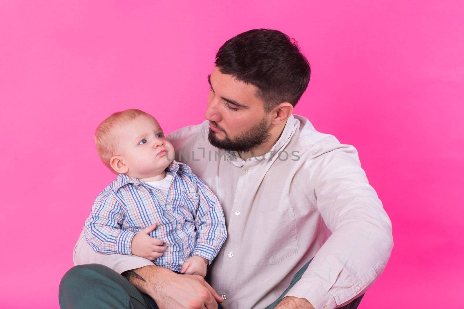 Happy father with his baby son on pink background by Satura86
