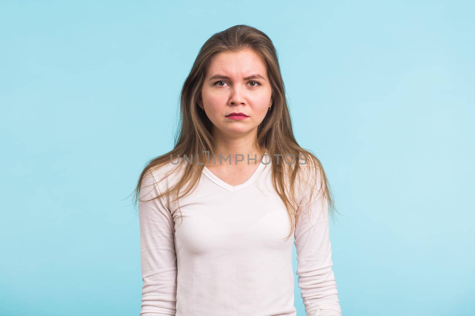 Portrait of sad woman standing on blue background by Satura86