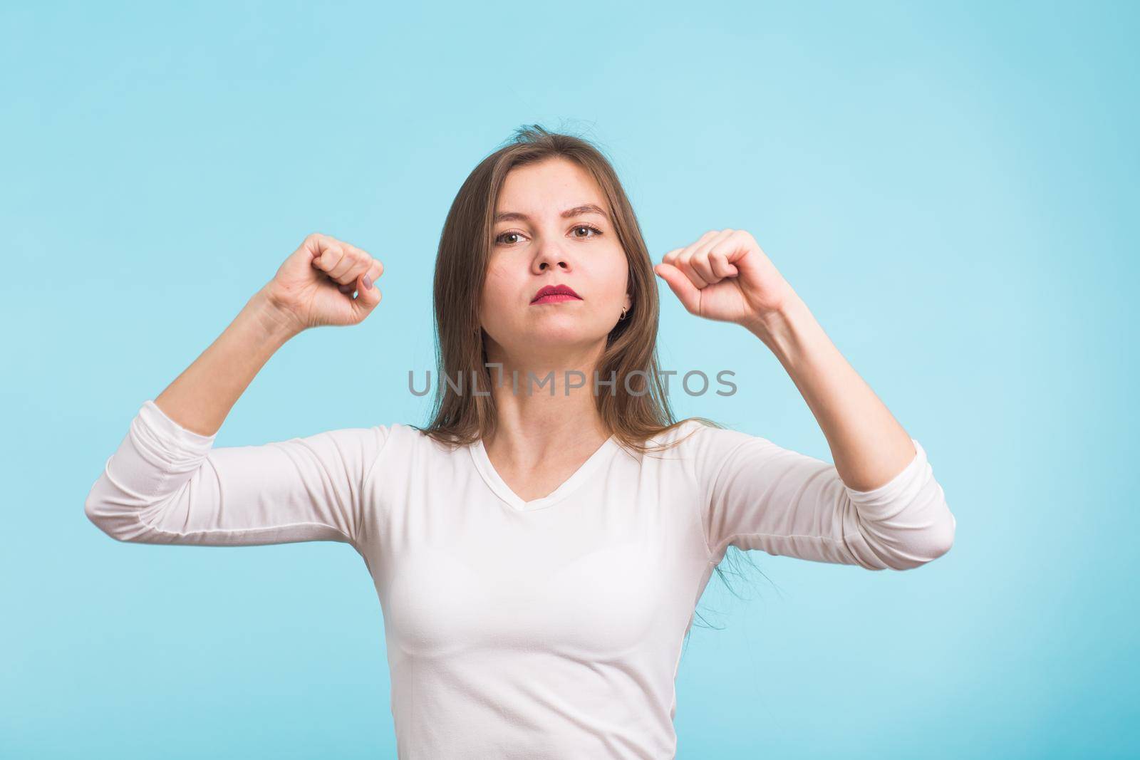 Superhero girl. Confident young woman isolated on blue background by Satura86