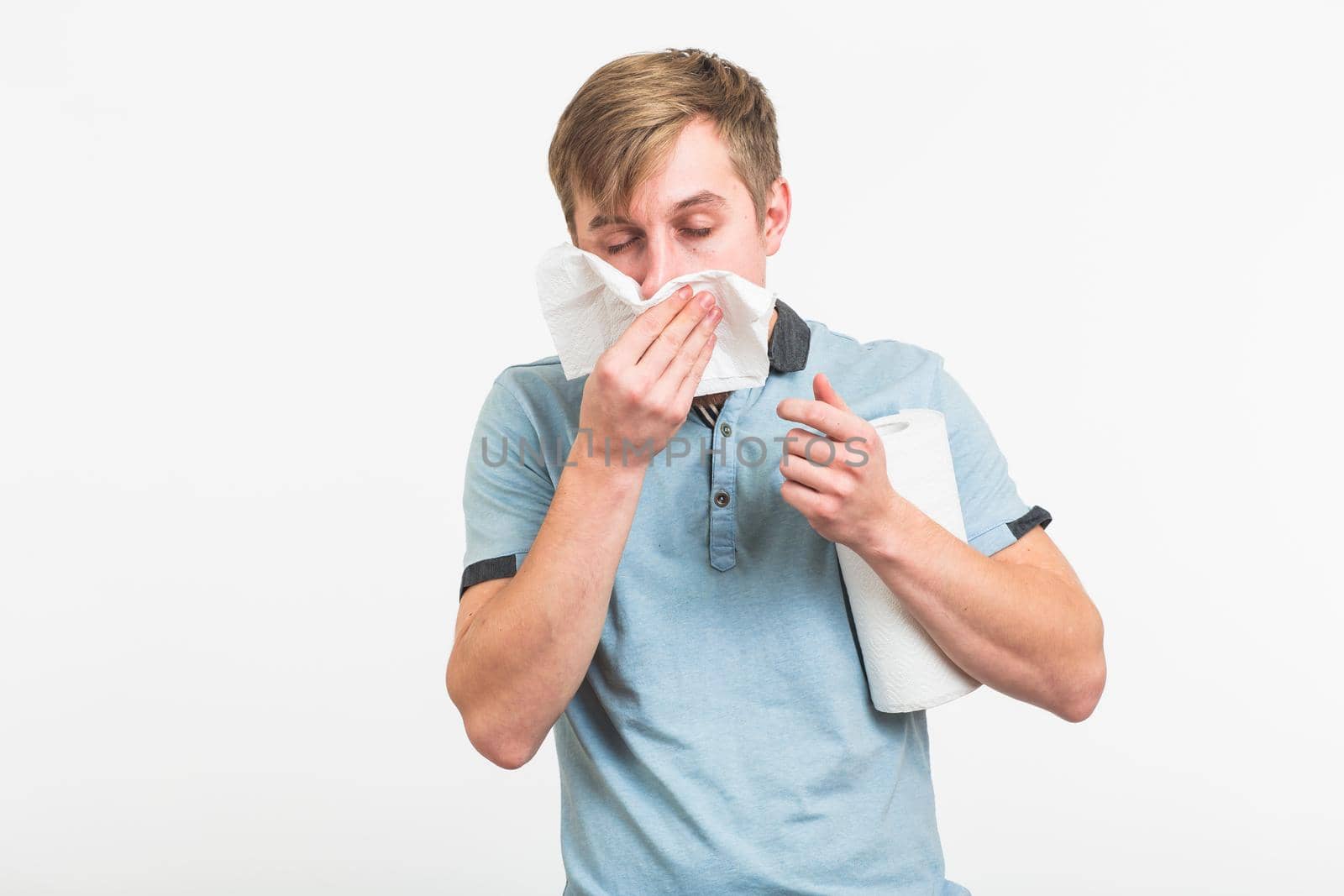 Young man has a runny nose on white background by Satura86