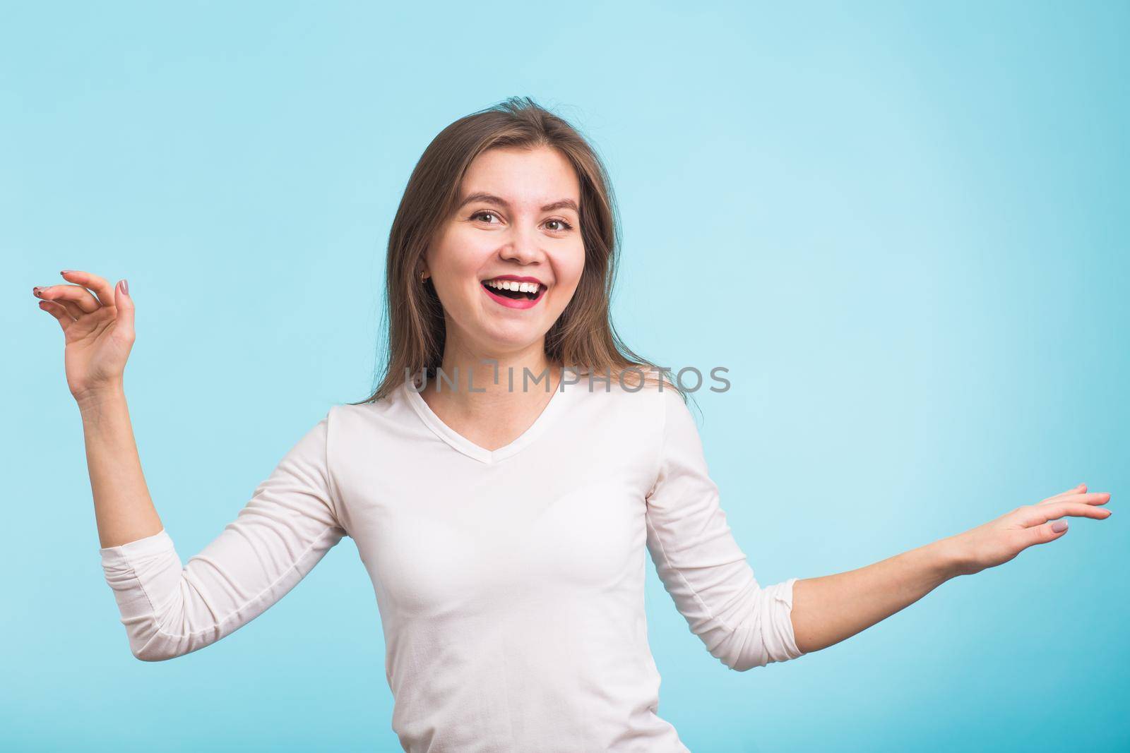 Energy girl dances on blue background in studio