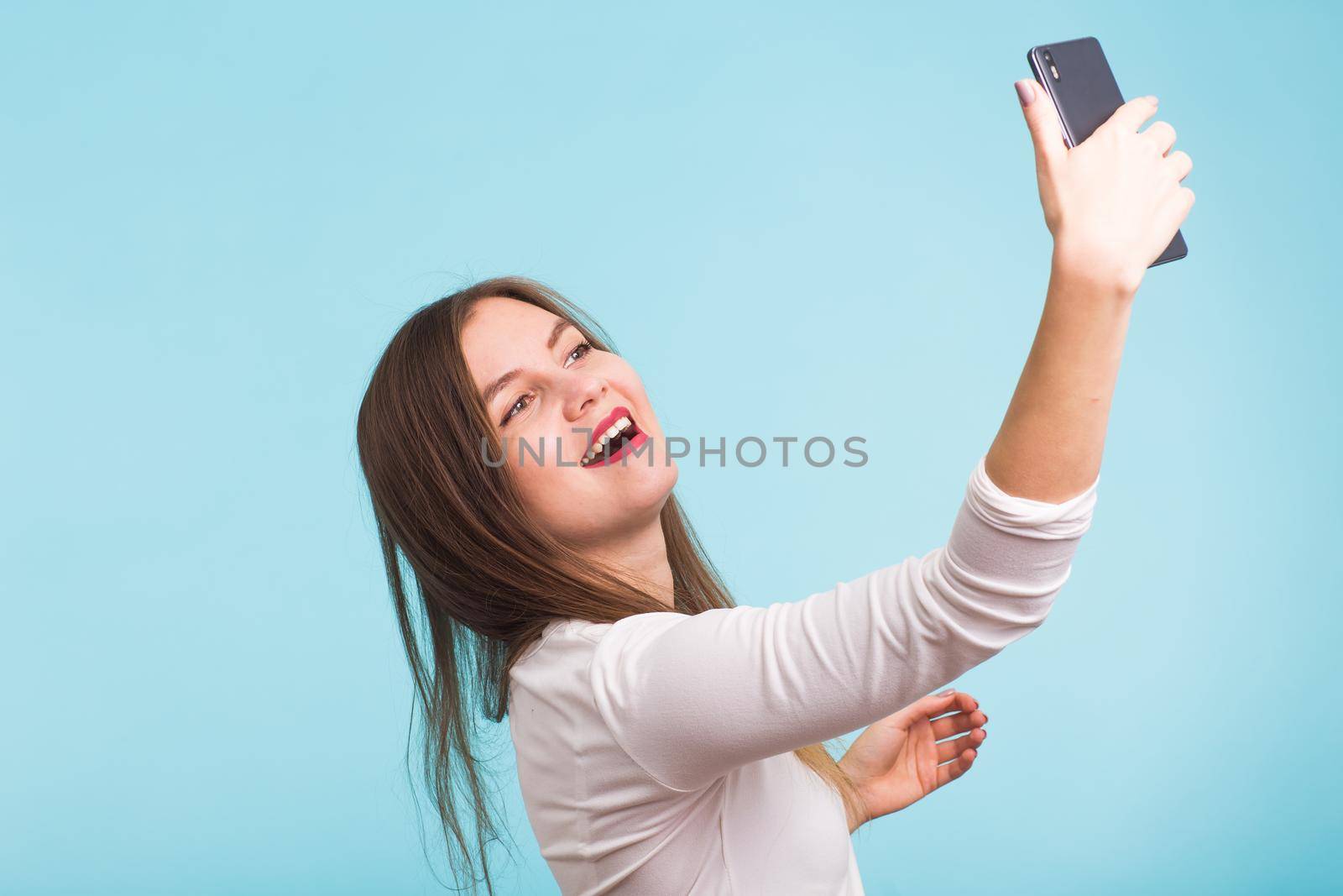 Young woman talking with friend through a video call on a smartphone. Beautiful girl having a video chat with man on mobile phone. by Satura86