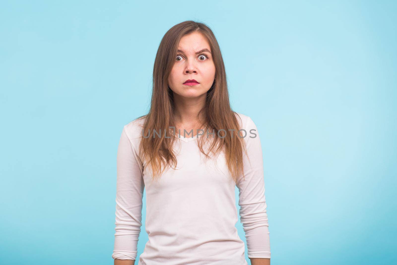shocked young woman, isolated against blue studio background by Satura86