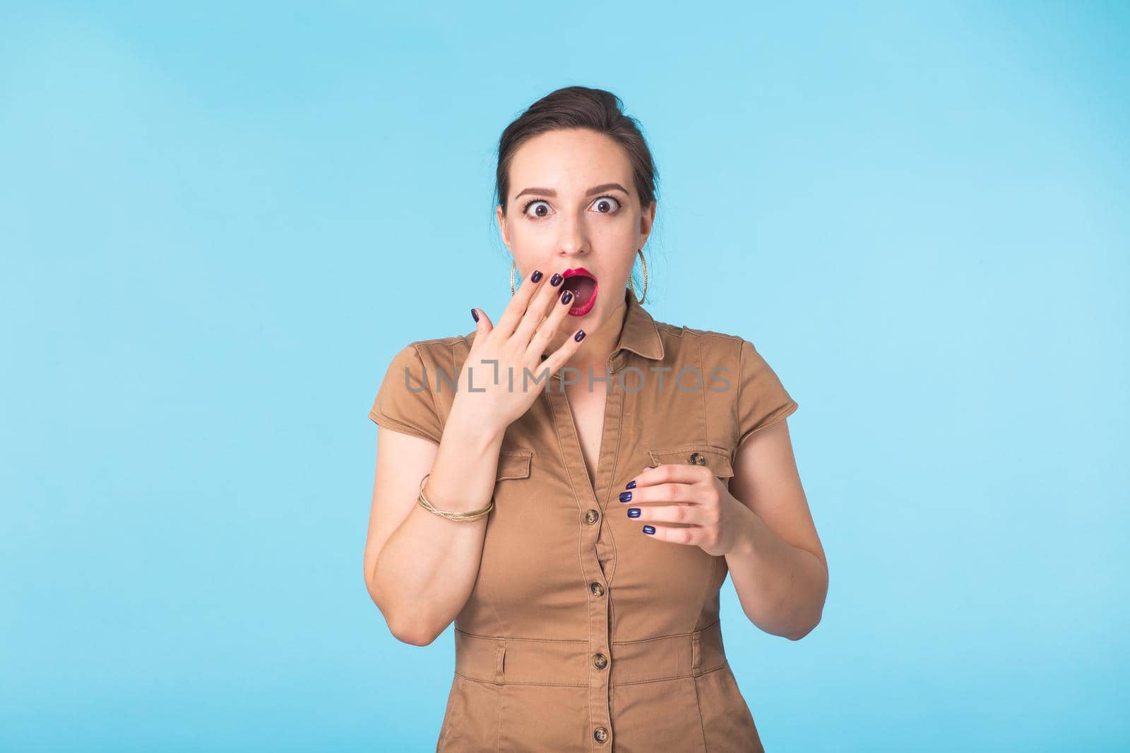 Portrait of young beautiful ginger woman with freckles cheerfuly smiling looking at camera. Isolated on pastel blue background. Copy space.